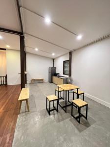 una habitación con dos mesas y bancos. en House Ju, en Bangkok
