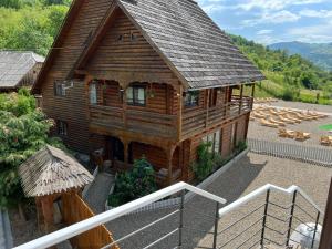 a large wooden cabin with a roof at Pensiunea Mara Băile Botiza in Botiza