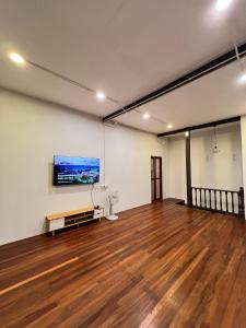 Habitación con suelo de madera y una pintura en la pared. en House Ju, en Bangkok