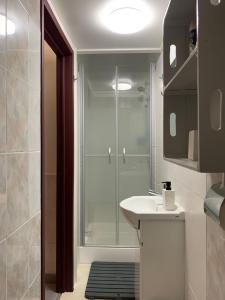 ein Bad mit einer Dusche und einem weißen Waschbecken in der Unterkunft Casa Touriga in Arruda dos Vinhos