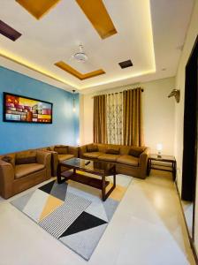 a living room with a couch and a table at Own It Apartment Brown in Islamabad