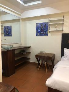 a bathroom with a sink and a desk and a bed at Serviced studio Apt at CBD in Dar es Salaam
