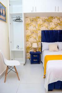 a bedroom with a blue and yellow bed and a chair at Blessed homes in Nairobi