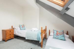 um quarto com 2 camas e uma cómoda em madeira em Blue Cottage - 3 bedroom cottage in Feock em Feock