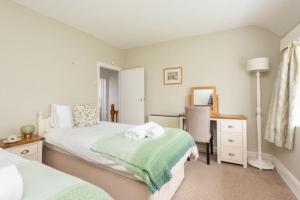 a bedroom with two beds and a desk and a desk at Blue Cottage - 3 bedroom cottage in Feock in Feock