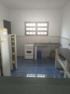 a kitchen with a stove and a tile floor at Casa Itanhaem in Itanhaém