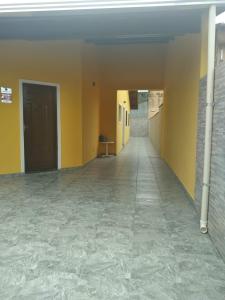 an empty hallway with yellow walls and tile floors at Casa Itanhaem in Itanhaém