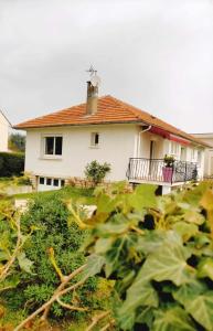 ein Haus im Hintergrund mit einem Feld von Pflanzen in der Unterkunft L'étape Nuitonne - Gîte avec jardin pour 6 personnes in Nuits-Saint-Georges