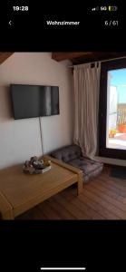 ein Wohnzimmer mit einem Couchtisch und einem TV in der Unterkunft Villa Colonia in Campofilone