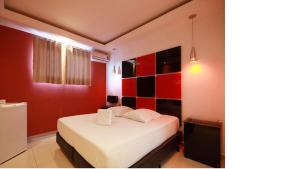 a bedroom with a white bed and red walls at Minuty Motel Itu in Itu +1 photo