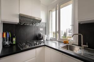 a kitchen with a stove and a sink and a window at Appartement spacieux aux portes de Paris in Châtillon +6 photos