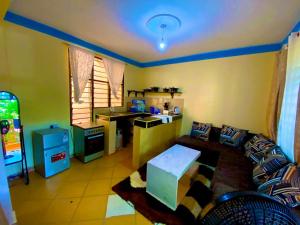 salon z kanapą i kuchnią w obiekcie Julia Top Holiday Home w mieście Diani Beach