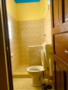 mała łazienka z toaletą i prysznicem w obiekcie Julia Top Holiday Home w mieście Diani Beach