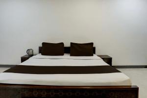 een bed met twee kussens erop bij OYO Flagship SAADAR HOTEL AND BANQUET in Kānpur