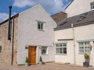a white brick house with a wooden door at 1 Bed in Richmond 88589 in Easby