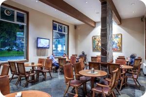 un restaurante con mesas y sillas y personas sentadas en mesas en Gran Hotel Isabel Riquelme, en Chillán