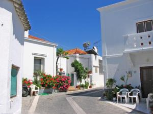 a street of white buildings with chairs and flowers at M&K Traditional House in Theologos