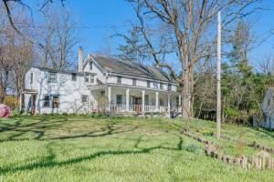 Biały dom z werandą i dziedzińcem w obiekcie Eagleville Home with Porch, Near Valley Forge Casino w mieście Eagleville