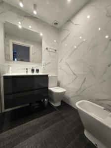 a bathroom with a sink and a toilet and a mirror at Piso en pleno Centro de Gijón al lado de la Playa in Gijón