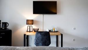 a desk with a chair and a television on a wall at Si-View Doppelzimmer mit Balkon Zimmer 8 in Siegen