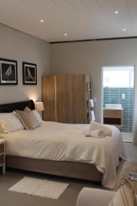 a bedroom with a large bed and a window at Sea Breeze Cottage in Cape Town