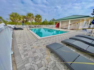 ein Schwimmbad mit Liegestühlen und ein Haus in der Unterkunft St James Golf Resort 331 Penthouse 3/3 sleeps 8 gated pool 1dog ok in Big Blackjack Landing