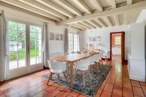 ein Esszimmer mit einem Holztisch und weißen Stühlen in der Unterkunft Bourgeois house and idyllic garden in Le Thuit-Simer