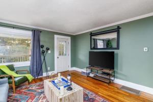 a living room with a couch and a tv at Lovely Cottage w Hot Tub & Grill New River Gorge in Oak Hill