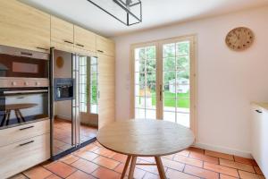 uma cozinha com uma mesa e um relógio na parede em Bourgeois house and idyllic garden em Le Thuit-Simer