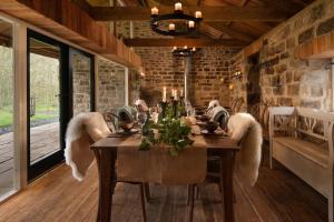 a dining room with a long table with angel wings at Broadgate Farmhouse in West Woodburn