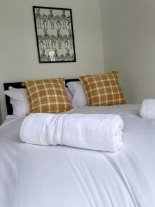 a white bed with two towels on top of it at University View-Off-Street Parking-Sleeps 8-Fast WiFi in Nottingham