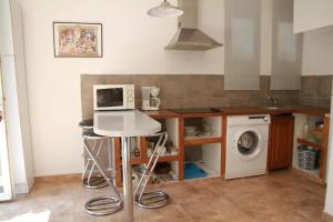 y cocina con encimera, microondas y lavadora. en Appartement, en Biguglia