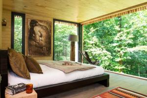 a bedroom with a bed and a large window at Loire Valley Lodges - Hotel in Esvres +246 photos