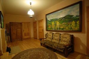 uma sala de estar com um sofá e uma pintura na parede em Pensjonat Jeleni Róg em Szklarska Poręba