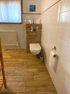 La salle de bains est pourvue de toilettes et d'un rouleau de papier toilette. dans l'établissement Domek nad jeziorem Guzowy Piec, à Guzowy Piec