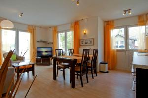 a living room with a dining room table and chairs at Zinnowitz, Fewo Sonnendomizil in Zinnowitz