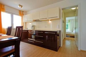 a kitchen with white cabinets and a table and a dining room at Zinnowitz, Fewo Sonnendomizil in Zinnowitz +8 photos