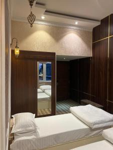 a bedroom with two beds and a mirror at Horizon Boutique in Samarkand