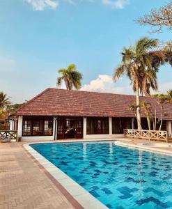 - une piscine en face d'une maison avec des palmiers dans l'établissement Cabaña en Playa del Francés, à El Puertón