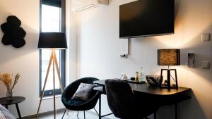 Habitación con escritorio, 2 sillas y TV. en SI-View Einzelzimmer Zimmer 9 en Siegen