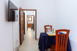 a dining room with a table and chairs and a hallway at JRéside Appart SOLO-DUO 30m2 centre ville in Cotonou