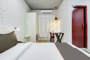 - une chambre avec un lit et une porte rouge dans l'établissement Collection O Airport View Guest House Airport Road, à Soalkuchi