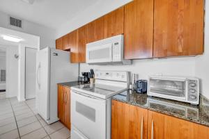 a kitchen with white appliances and wooden cabinets at Deluxe 1 Bedroom Apartment • Brickell • Ocean View in Miami