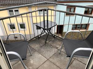 two chairs and a table on a balcony at Mani´s Feriendomizil Neuwied in Neuwied +1 photo