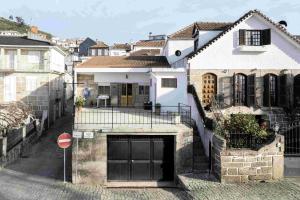 uma casa branca com uma garagem numa cidade em Alojamento Local Servinho Sebastião Maria em Sanfins do Douro