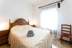 een slaapkamer met een bed met twee handdoeken erop bij Alojamento Local Servinho Sebastião Maria in Sanfins do Douro
