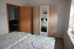 ein Schlafzimmer mit einem Bett und einer Tür zu einem Zimmer in der Unterkunft Ferienwohnung Gundermann in Quedlinburg