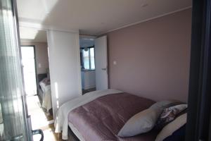 Modernes festliegendes Hausboot mit großzügiger Dachterrasse und Ruderboot客房内的一张或多张床位
