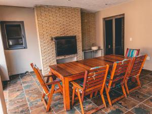 a dining room with a wooden table and chairs at Khutso Boutique Hotel in Hazyview