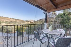 a patio with a table and chairs on a balcony at Paraje fuente del pintor in Iznalloz